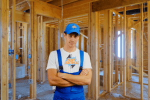 An electrician wearing a blue cap and jumper